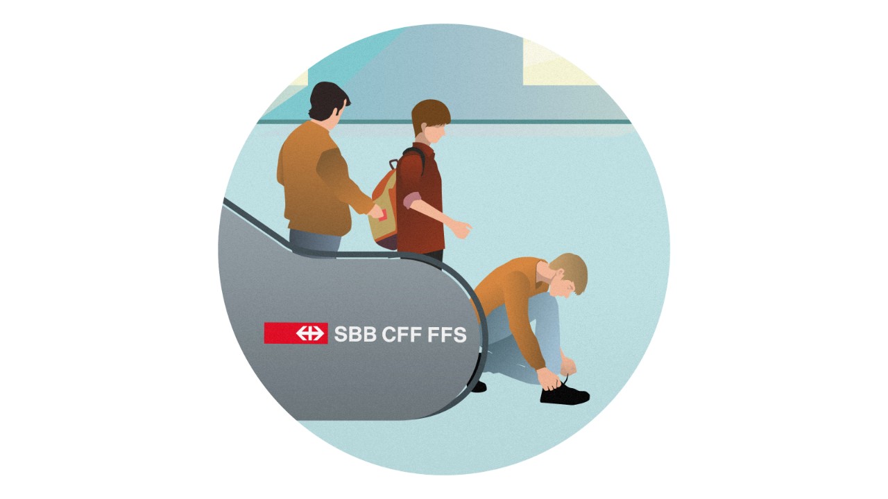 Un homme s'agenouille au bas d'un escalator pour faire ses lacets. Le passant qui marche derrière lui doit s'arrêter. Derrière le passant, un complice récupère les objets de valeur dans le sac à dos du passant.