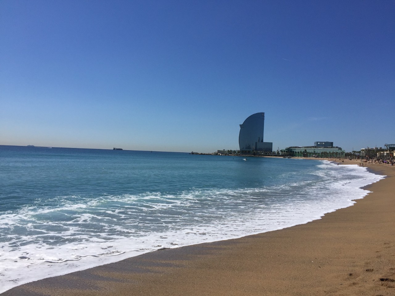 La plage de Barcelone et la vue sur le bâtiment de l’hôtel 5 étoiles «Vela» (voile).