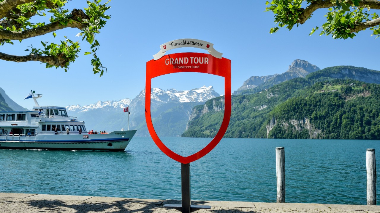 A passenger boat passing in front of the promenade in Brunnen.