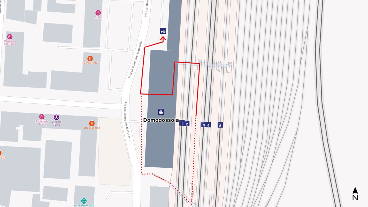 The map shows a bird’s eye view of Domodossola railway station, with south at the bottom and north at the top of the map extract. To get to the rail replacement bus, go from your arrival platform through the main station hall and then turn right. 
The distance is about 240 metres and takes 3 minutes to walk.