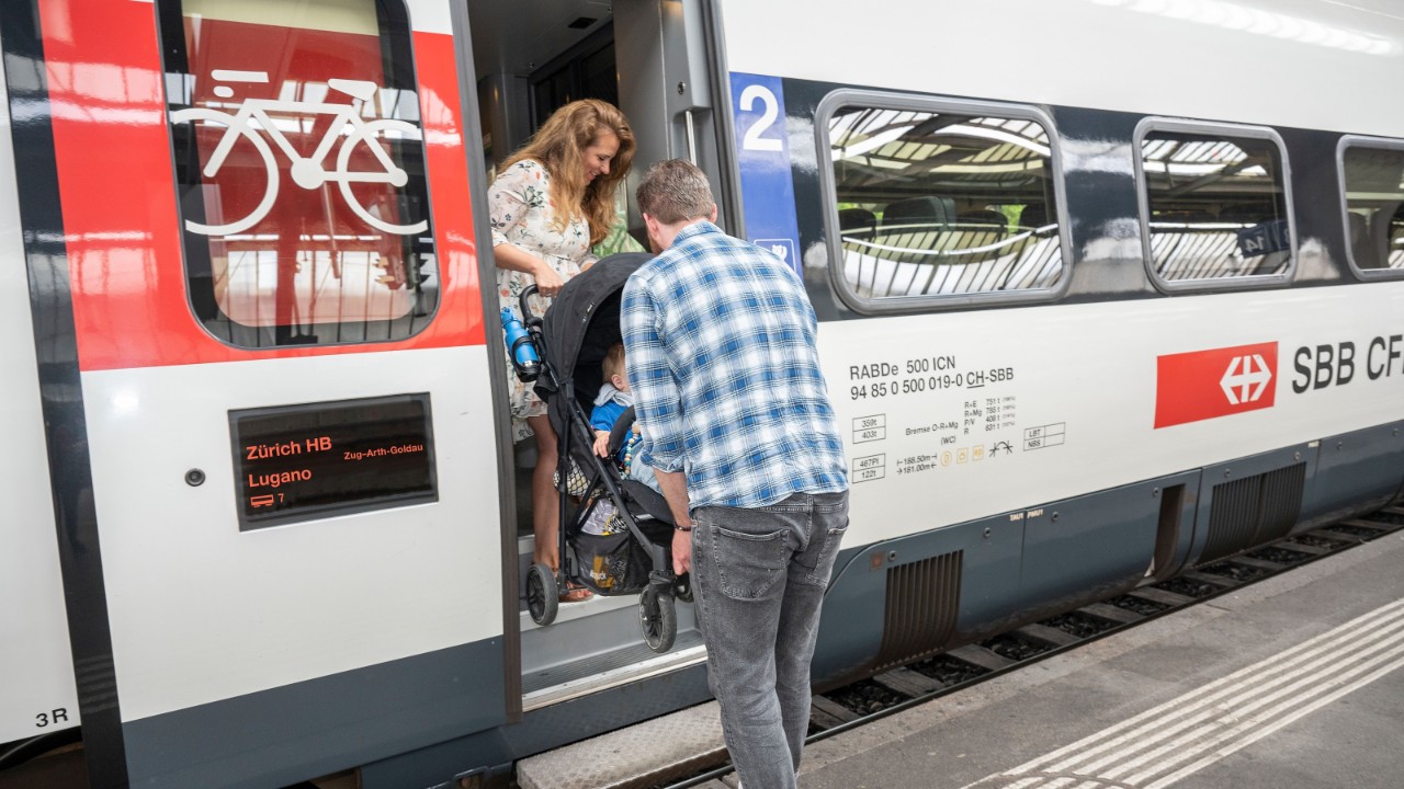 Gira il passeggino con il manubrio rivolto verso il treno. Una persona entra per prima e afferra il manubrio dall’alto, mentre un’altra persona resta sul marciapiede a tenere una barra trasversale in corrispondenza delle ruote. Poi sollevate insieme il passeggino sul treno.